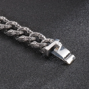 Macro detail of gothic skull pattern engraving on vintage stainless steel curb chain bracelet