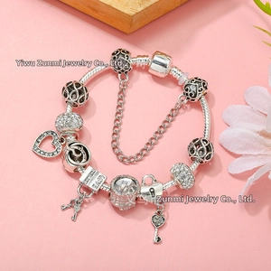 Detail of silver snake chain bracelet with love charms and crystal heart pendant