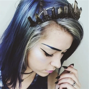 Close-up of handmade brown moon crown with natural crystals on dark metal base