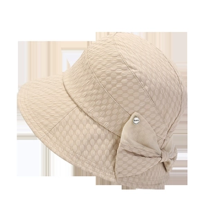 Detail view of beige sun hat featuring textured bubble fabric and a large side bow design
