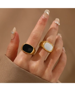 Close-up of minimalist black and white square rings on model fingers with gold plating