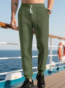 Dettaglio dei pantaloni jogger verdi da uomo con trama jacquard e coulisse bianca