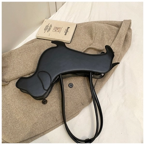 Detail of creative dog-shaped black leather underarm bag on stylish beige blazer