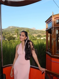 Détail d'une robe rose à licou avec ourlet à volants dans un tramway vintage rouge