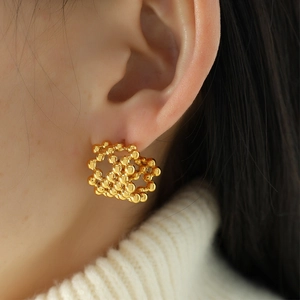 Minimalist 18K gold plated mesh C-shaped beaded stud earrings worn by a model