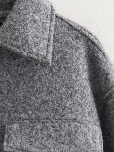 Close-up of the grey bouclé wool texture and seam details on this warm autumn jacket