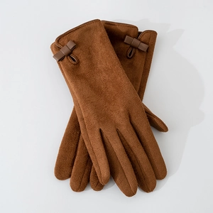 Detailed view of brown suede gloves featuring a decorative leather bow on the wrist cuffs