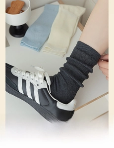 Detail of ribbed knit women's crew socks in dark grey, light blue, and beige colors