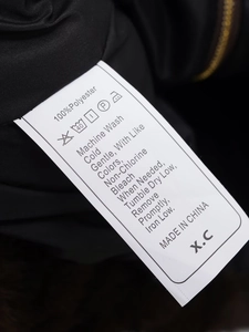 Detail of the wash care label showing 100% polyester material and washing instructions