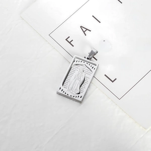 Macro view of silver stainless steel pendant with engraved Padre Nuestro prayer and relief