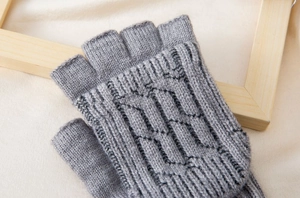Close-up of grey cable knit wool texture and fingerless design on warm winter glove