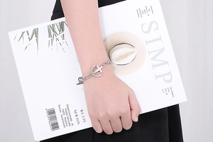 Close-up of vintage stainless steel anchor and cross pendant on thick chain link bracelet