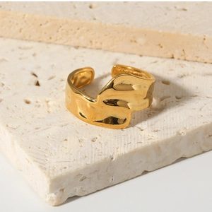 Detailed view of adjustable gold-plated ring with organic hammer texture on travertine stone