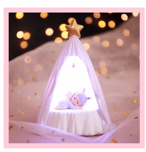 Detailed view of LED night light with sleeping angel and gold star decoration