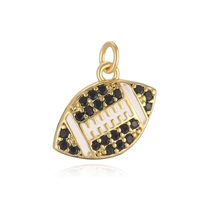 Golden football pendant with black stones and white enamel detail on white background