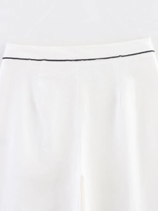 Detailansicht einer weißen Hose mit schwarzer Paspelierung und eleganten Ziernähten