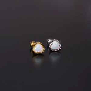 Macro detail of gold and silver heart opal stud earrings with secure screw back design