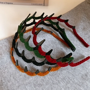 Macro detail of velvet wavy headbands in four colors on a soft knitted fabric