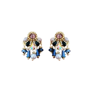 Vintage gold drop earrings with purple blue crystals and white pearls on white background