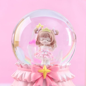 Close-up of pink crystal ball music box with crown princess and glitter stars decor