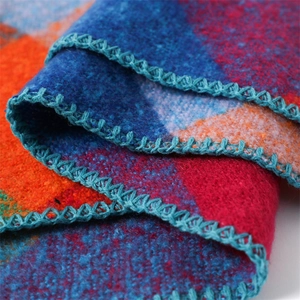 Close-up of colorful checkered cashmere scarf with detailed cyan crochet fringe