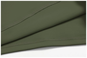 Macro detail of olive green yoga top featuring professional double-stitch hem and fine texture