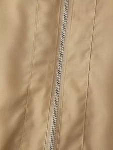 Vue macro de la texture du tissu kaki et du détail de la fermeture éclair métallique