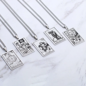 Detail of five silver tarot card pendants including Death and Sun on marble background