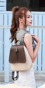 Detail of minimalist color-block backpack with lettered straps and flap pocket design