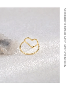 Detail of gold plated ring showing heart-shaped hollow design on textured surface