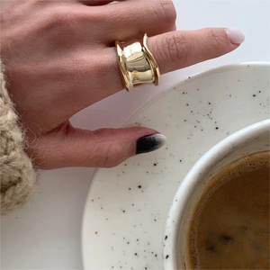 Minimalist wide gold irregular sterling silver ring worn in a stylish lifestyle setting