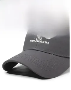 Detail of dark gray baseball cap showing white embroidery and stitching on cotton fabric