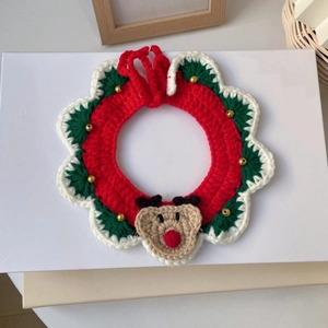 Détail d'un collier de Noël tricoté main pour animaux avec renne et perles dorées festives