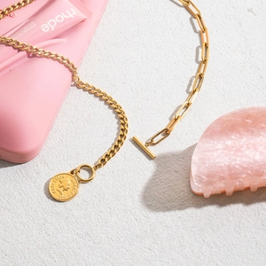 Gold coin necklace with Elizabeth II pendant and OT toggle clasp on textured backdrop