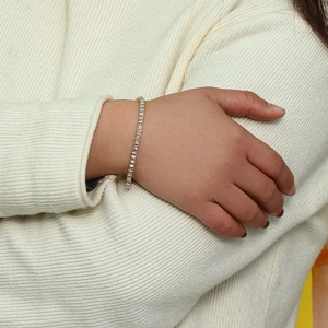 Gros plan d'un bracelet de tennis doré avec des cristaux de zircone cubique carrés