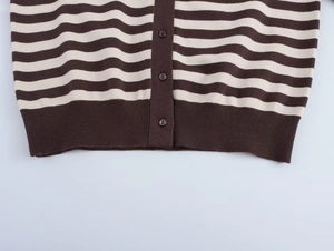 Detail of striped knit cardigan showing brown buttons and ribbed hem texture