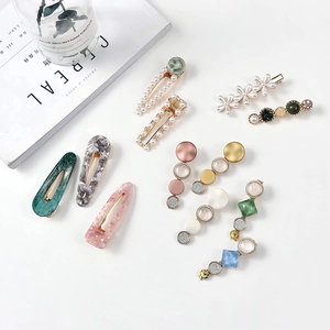 Detailed flat lay of acrylic acetate hair clips and pearl barrettes in various candy colors