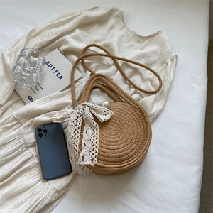 Round straw woven bag in camel with lace bow, pearl detail and crossbody strap