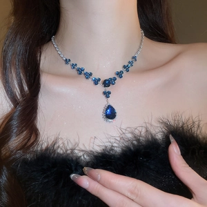 Detailed view of elegant blue zircon flower necklace and matching earrings on a model