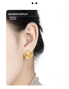 Detailed view of gold ginkgo leaf studs with crystal accents on a model side profile
