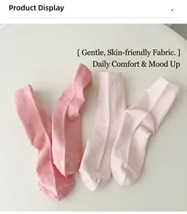 Vue détaillée de chaussettes en coton rose avec revers sur un fond en bois douillet