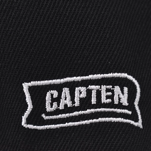 Macro-opname van het witte CAPTEN-borduurwerk op de zwarte stof van de Brooklyn-pet