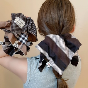 Detail view of oversized striped fabric scrunchie with textured cotton and woven label