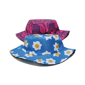 Set aus geblümten Sommer-Fischerhüten mit blauen Gänseblümchen und magentafarbenen Tulpen