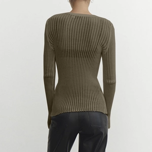 Detail view of the ribbed knit fabric and slim fit design on the back of the olive green top
