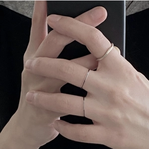 Close-up of three minimalist 925 silver rings with wave textures and sleek slim bands