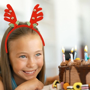 Close-up of red Christmas reindeer antler headband with golden bells and holly leaves