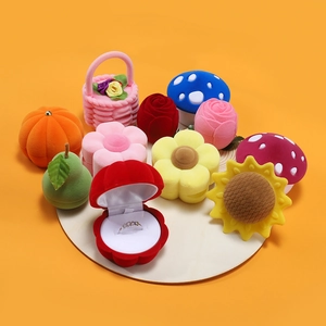 Variety of cute velvet jewelry boxes in plant and fruit shapes on a white base
