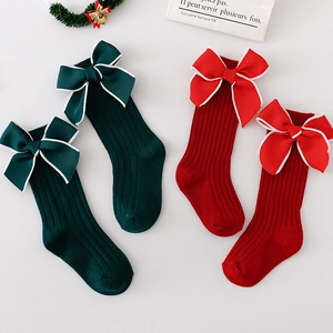 Christmas baby bow socks in red and dark green featuring oversized bow decorations