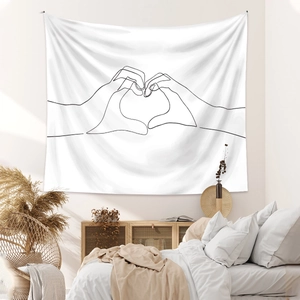 Detailed view of white line art tapestry with hand heart pattern on a bedroom wall